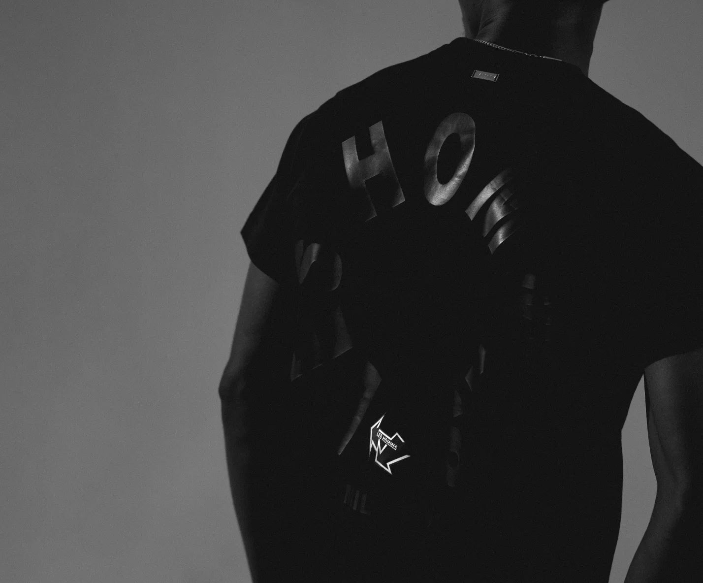 Les Hommes black t-shirt with black text and logo on a gray background