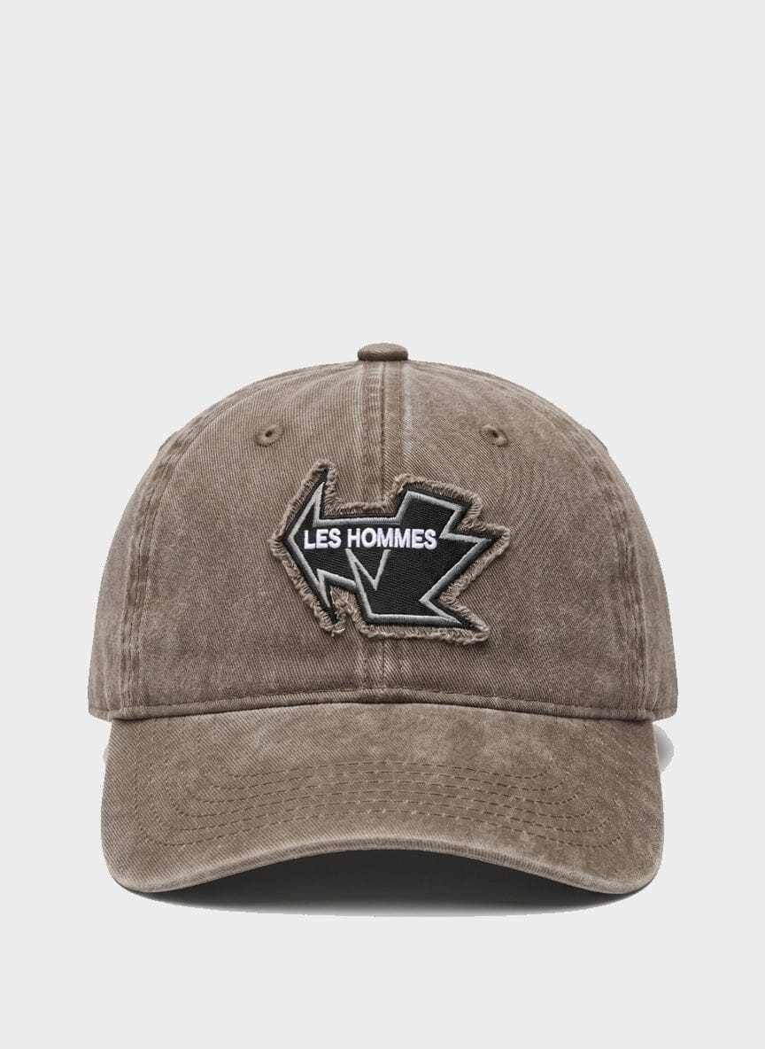 brown distressed baseball cap with an embroidered les hommes patch on the front