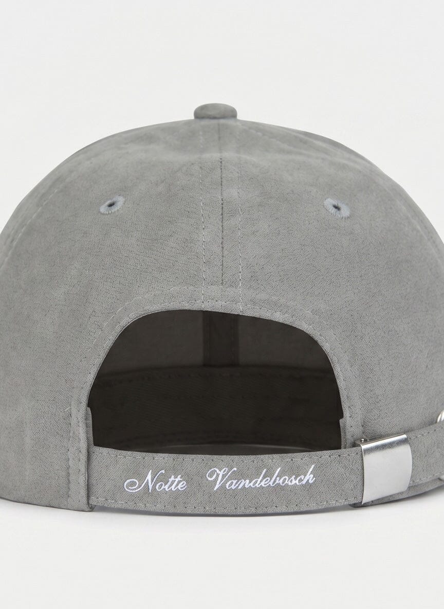back view of a grey cap with an adjustable strap and metal buckle; white embroidery reads Note Vandebosch on the strap