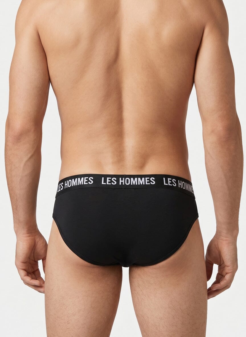back view of a man in black briefs with a waistband that says Les Hommes