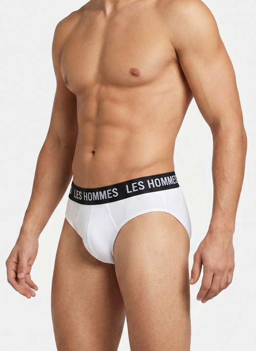 man wearing white briefs with a black elastic waistband that reads Les Hommes