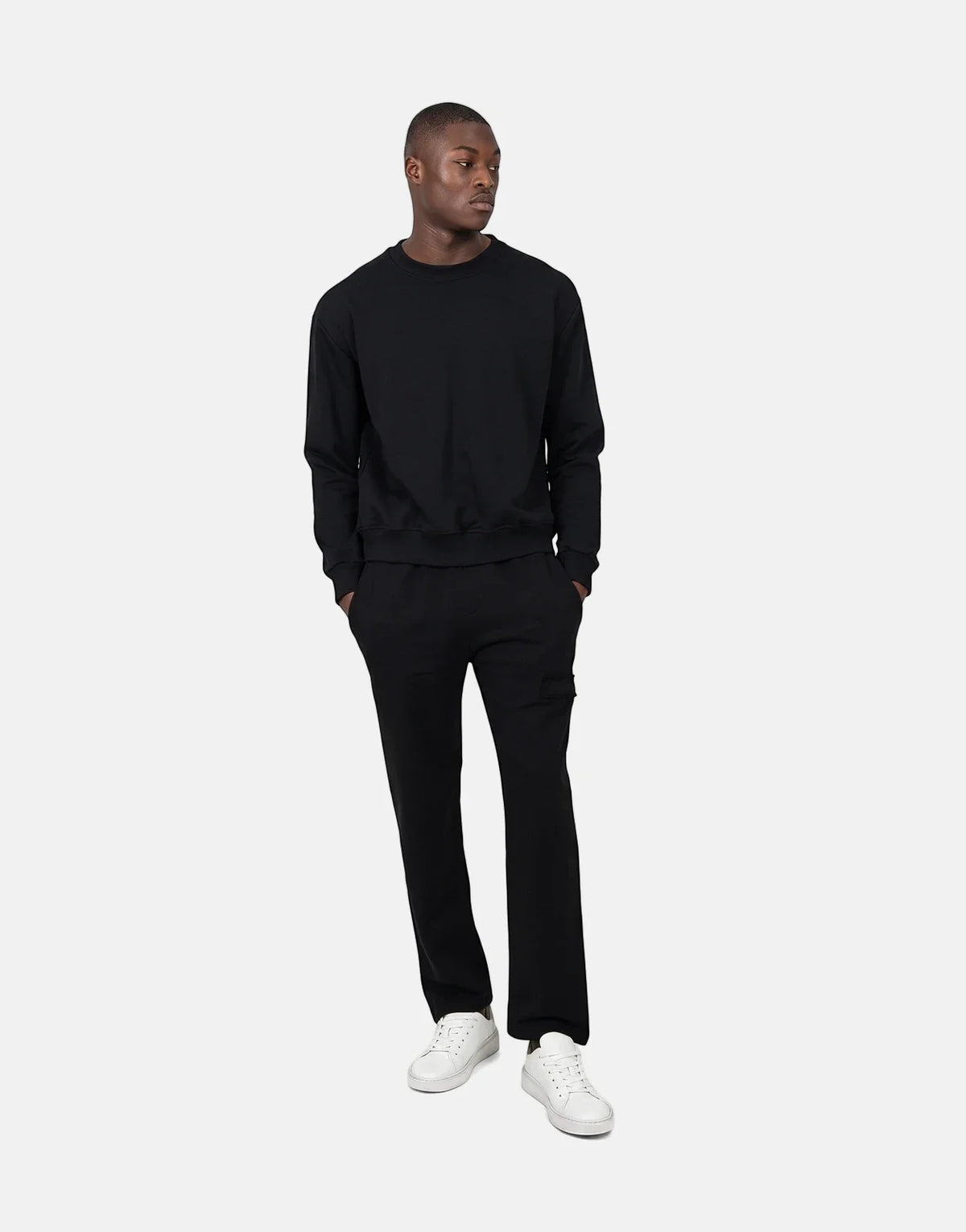 Les Hommes Black Jogger worn by a male model, styled with a black sweatshirt and white sneakers, offering a comfortable,