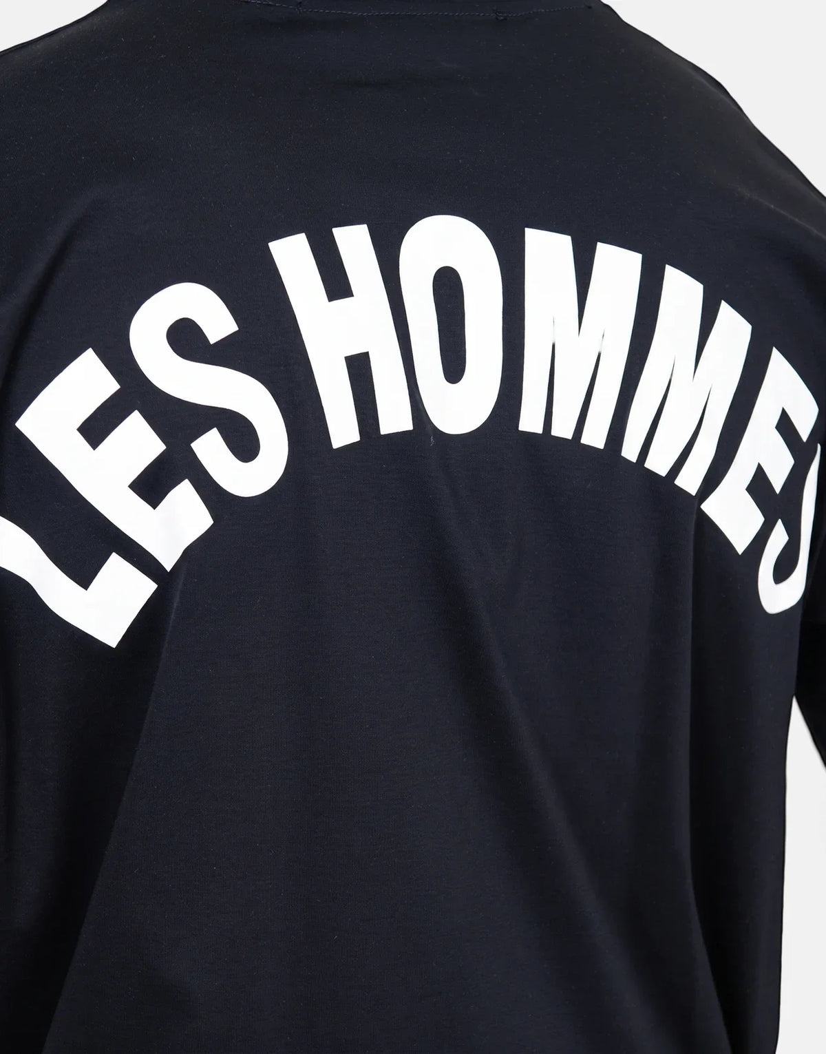 Les Hommes black t-shirt featuring a large white arched 'LES HOMMES' logo prominently displayed on the back, shown from the