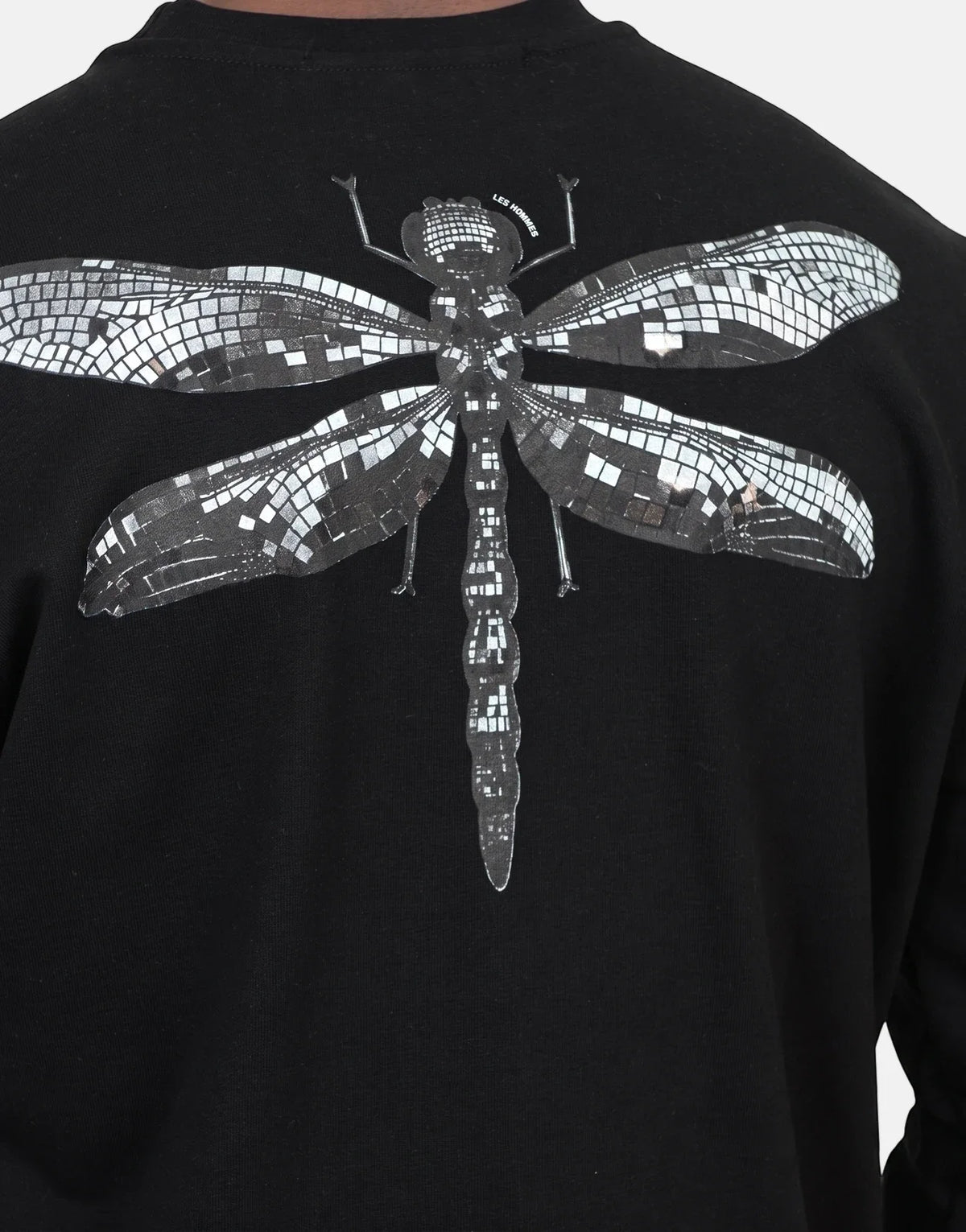 Les Hommes black sweatshirt featuring a detailed silver mosaic-style dragonfly graphic on the back. Close-up view.