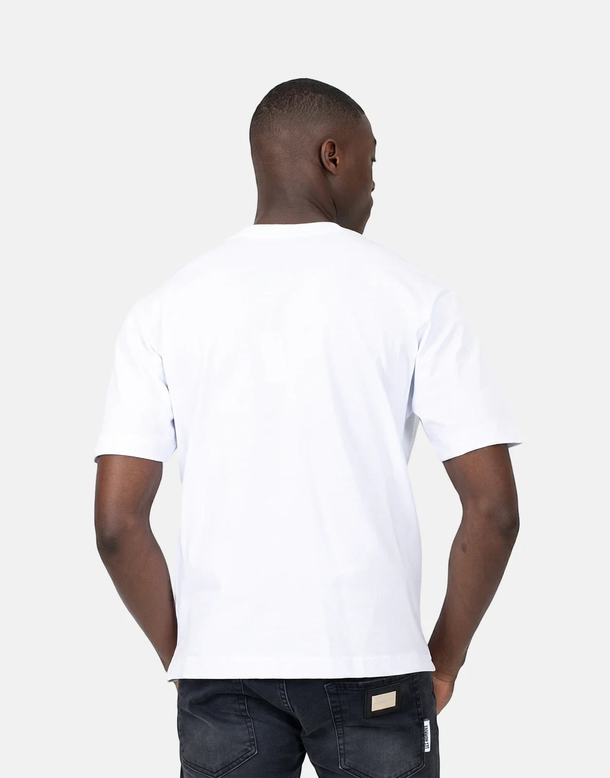 Les Hommes Dragonfly White T-Shirt on a male model, seen from the back wearing black jeans in a studio shot.