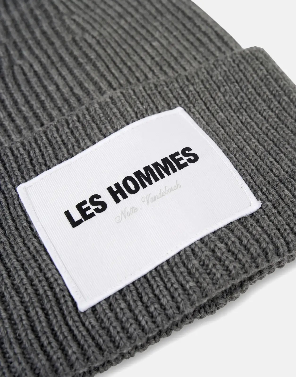 grey ribbed knit beanie with a white rectangular logo patch showing Les Hommes